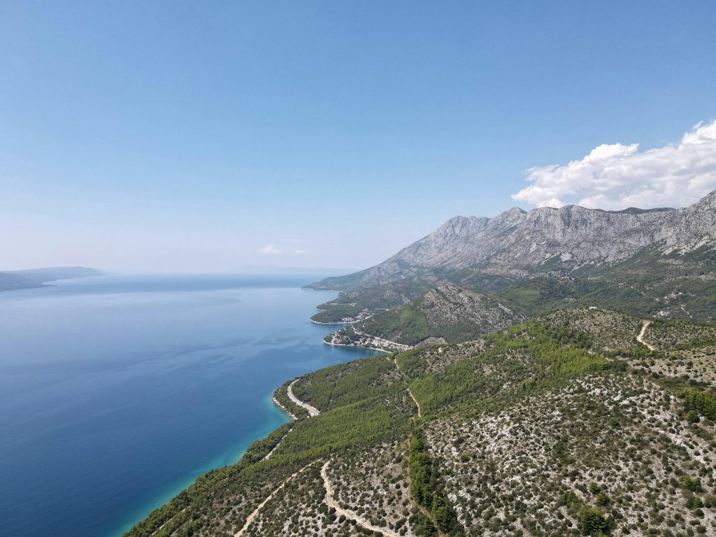 Stunning aerial view of Podaca, Croatia showcasing mountains and Adriatic Sea.